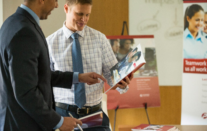 professional businessmen discussing printed brochure content during business presentation