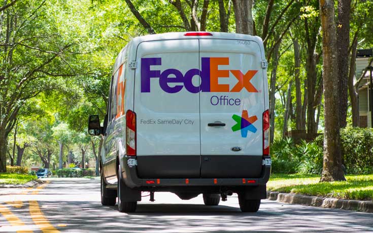 FedEx Office Same Day City van driving down a street