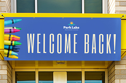A printed outdoor banner hanging outside a school welcoming students back