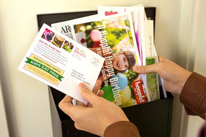 Person pulling out direct mail cards out of their mailbox