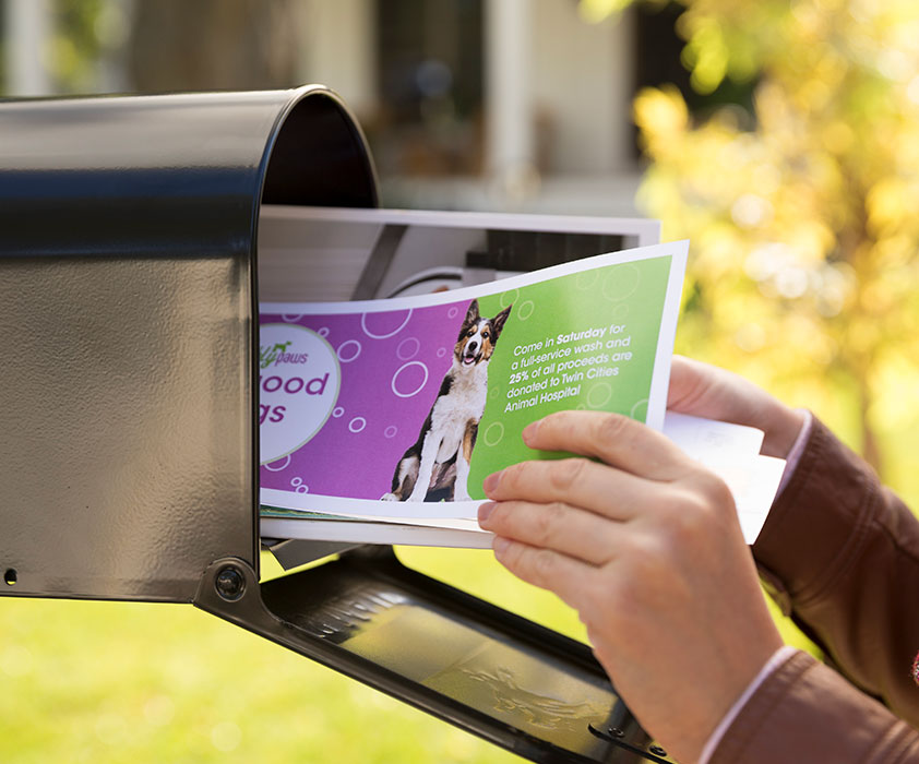 A person getting their mail with printed direct mail pieces